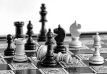 A black and white image of a chess board in play.
