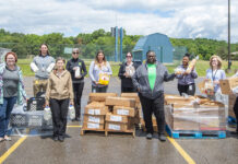 KCC staff members pose with boxes of food outside during a Fresh Food Distribution event.