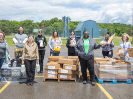 KCC staff members pose with boxes of food outside during a Fresh Food Distribution event.